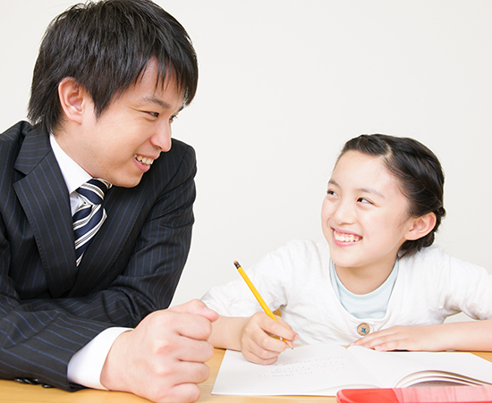 先生と笑顔で向き合う小学生